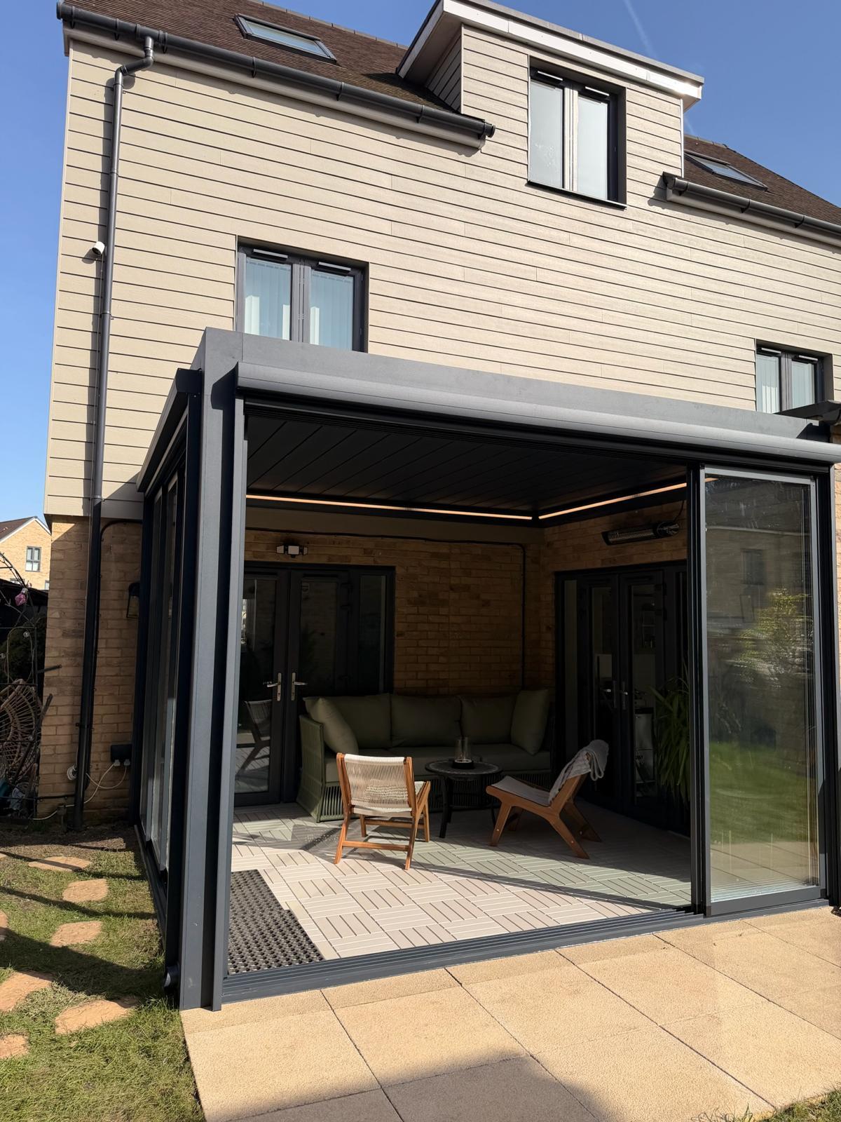 Exterior view of a glazed outdoor room attached to the rear of a house